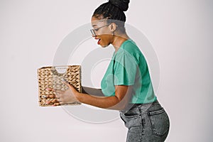 Beautiful African American woman standing holding basket. Happy surprised Black girl in white background