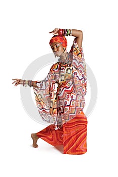 Beautiful African American woman in traditional clothes dancing in the studio