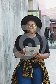 Beautiful African American woman using digital tablet watching movie outdoors or talking video call or social networks