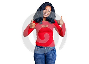 Beautiful african american woman wearing casual clothes success sign doing positive gesture with hand, thumbs up smiling and happy