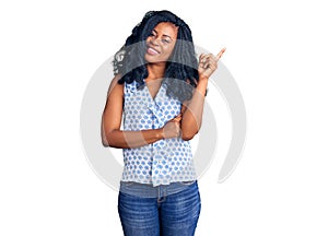 Beautiful african american woman wearing casual summer shirt with a big smile on face, pointing with hand and finger to the side