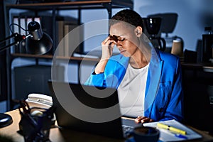Beautiful african american woman working at the office at night tired rubbing nose and eyes feeling fatigue and headache
