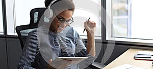 Beautiful african american woman is working using digital tablet while sitting in creative office