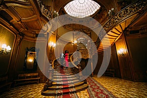 Beautiful african couple going down on vintage stairs. Luxurious theatre interior background
