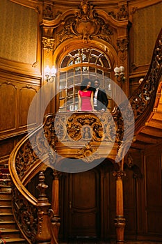 Beautiful african couple posing on the vintage stairs. Luxurious theatre interior background