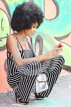 Beautiful African girl taking pictures of herself with mobile phone