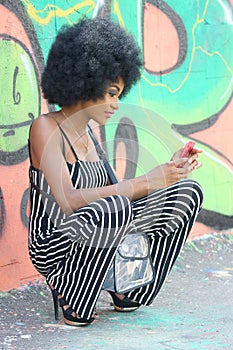 Beautiful African girl taking pictures of herself with mobile phone