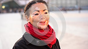 Beautiful african girl with vitiligo standing on the street talking and smiling.