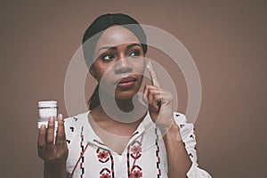 Beautiful African woman apply face cream.