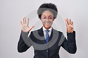 Beautiful african woman with curly hair wearing business jacket and glasses showing and pointing up with fingers number nine while