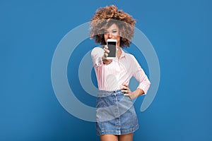 Beautiful african woman holding mobile phone and smiling.