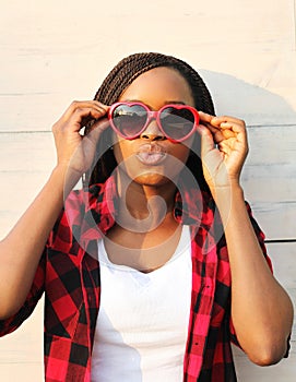 Beautiful african woman in red sunglasses having fun