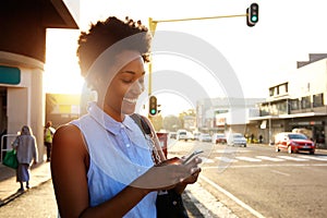 Beautiful african woman using cellphone outdoors