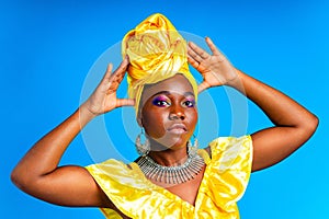 beautiful african woman in yellow silk turban on head and dress with silver neckless and earrings , nose piercing in
