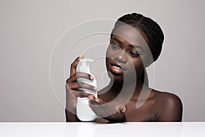 Beautiful african young woman face spray on face lotion cosmetology on white background