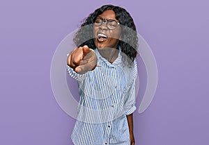 Beautiful african young woman wearing casual clothes and glasses pointing displeased and frustrated to the camera, angry and