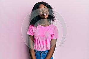 Beautiful african young woman wearing casual pink t shirt with a happy and cool smile on face