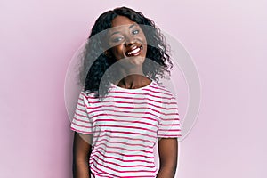 Beautiful african young woman wearing casual striped t shirt with a happy and cool smile on face