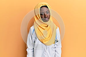 Beautiful african young woman wearing doctor uniform and hijab depressed and worry for distress, crying angry and afraid