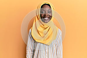 Beautiful african young woman wearing traditional islamic hijab scarf with a happy and cool smile on face