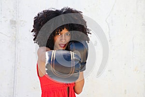 Beautiful Afro-American woman with boxing gloves claiming women`s rights against mistreatment and breast cancer. Concept of women