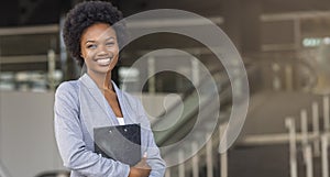 Beautiful Afro business woman holding a folder, looking at camera