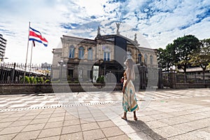 beautiful Afro-descendant woman looking around on a sunny day in the city of San Jose in Costa Rica with the National Theater in