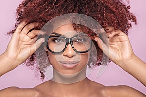 Afro girl in eyeglasses, smiling.