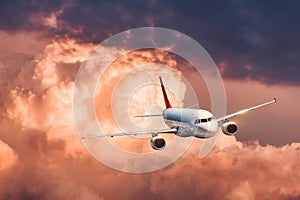 Beautiful airplane is flying in colorful clouds