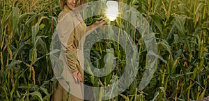 Beautiful alone girl in the corn garden enjoys a moment.Woman in retro clothes holds a mirror on corn field