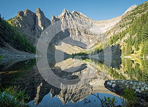 Beautiful alpine lake with still water surface reflecting its surroundings