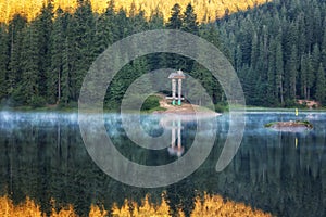 Beautiful alpine lake Synevyr in Carpathian mountains at sunrise with reflection in the clear water