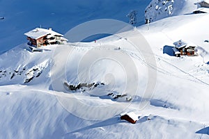 Beautiful alpine landscape with chalets, snow, sun and shadows in the Carpathians Mountains