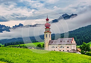 Beautiful alpine scenery of Vallabassa town with St. Stephen& x27;s church, Dolomite Alps, Italy photo