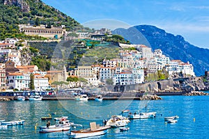 Beautiful Amalfi with hotels on hills leading down to coast, comfortable beaches and azure sea in Campania, Italy