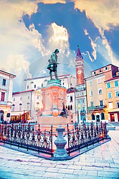 Beautiful amazing city scenery with the monument the famous Italian violinist and composer Giuseppe Tartini and old clock tower in