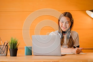 Beautiful ambitious Asian female employee working from home. girl using laptop smile like a dream Students feel inspired to write