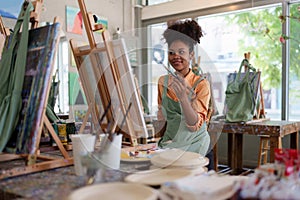 Beautiful american african artist woman painting in art studio at the university classroom