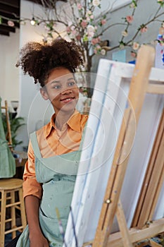 Beautiful american african artist woman painting in art studio at the university classroom