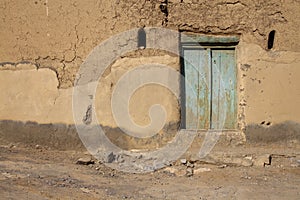 The beautiful ancient abandoned ruins mud or clay wall and wooden door of old house