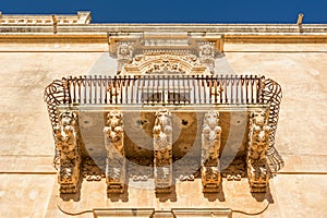 Beautiful ancient baroque balcony with horse ornaments in Noto, Sicily, Italy