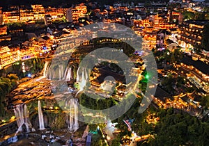 Beautiful ancient town in China with waterfall and traditional houses at night