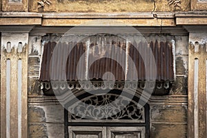 Beautiful ancient wooden stencil engraving windows and stucco pattern with and old yellow historical building exterior