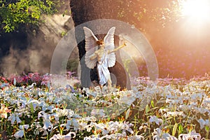 Beautiful  angel in a paradise magic garden with white and pink  lilies. Valentine`s day greeting card. Flower landscape.