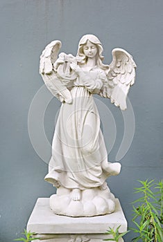 Beautiful angel statue against gray wall background