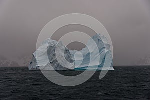 Beautiful antarctic landscape with iceberg and mountains