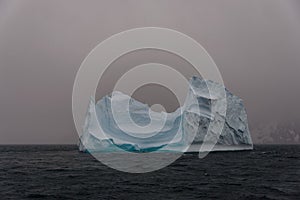 Beautiful antarctic landscape with iceberg and mountains