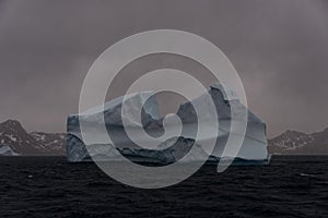 Beautiful antarctic landscape with iceberg and mountains