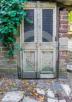 Beautiful antique baroque house door entrance with ivy leaves on the wall