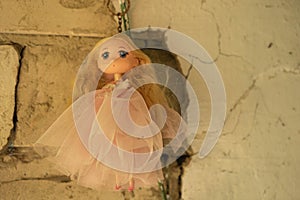 A beautiful antique doll hangs on a ruined wall of an abandoned house. Concept - mysticism, horrors